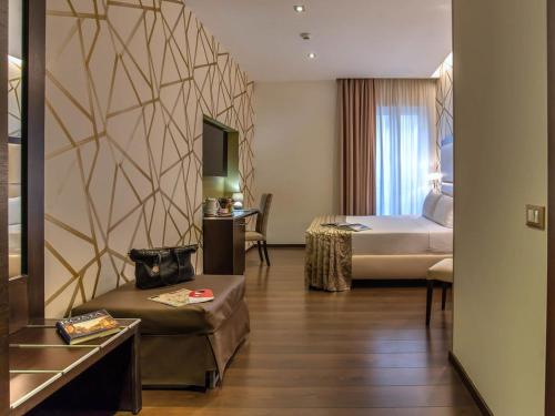 a hotel room with a bed and a couch at Hotel Infinity San Pietro in Rome