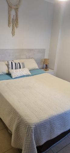 a large bed with white sheets and pillows on it at B & V departamentos in San Salvador de Jujuy
