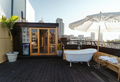 a bath tub sitting on the deck of a building at Casa Suzanna Hotel in Tel Aviv