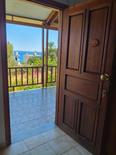 an open door to a balcony with a view of the ocean at studios Katerina A Lentas in Lentas