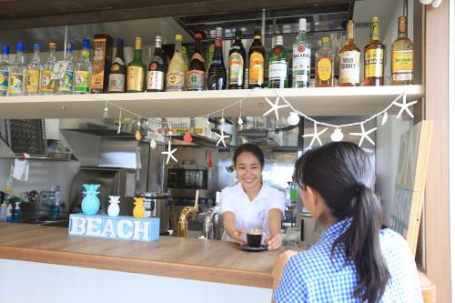 two women standing at a bar with a bartender at Seven Colors Ishigakijima in Ishigaki Island