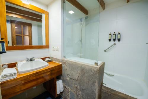 a bathroom with a sink and a shower at San Agustin Monasterio de la Recoleta in Urubamba
