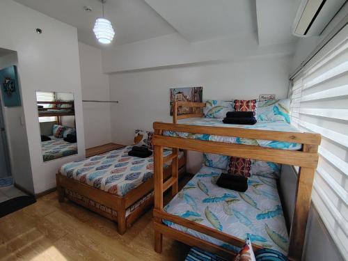 a bedroom with two bunk beds and a mirror at Tala Transient House in Baguio