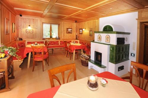 uma grande sala de jantar com mesas e uma lareira em Landhaus am Waldrand em Ramsau