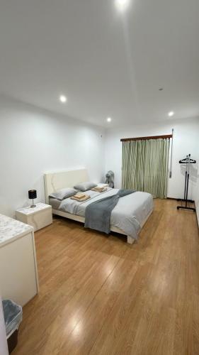 a bedroom with a bed and a wooden floor at Recanto da Paz in Pombal