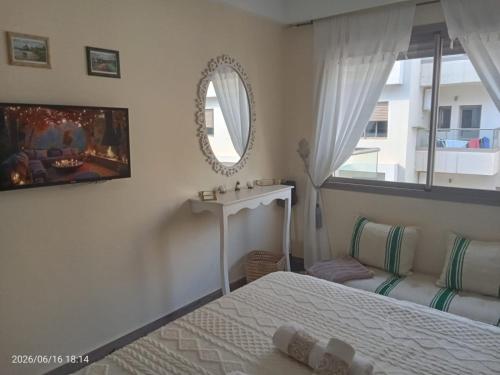 a bedroom with a bed and a sink and a mirror at sunny amazigh apt avev piscine pool steps from beach 2balcony 2smartTV pool in Essaouira