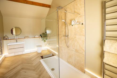 a bathroom with a shower with a glass door at The Byre in Penrith