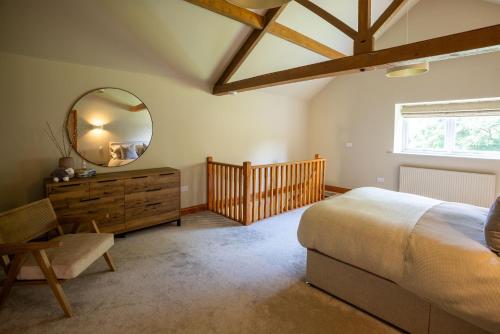 a bedroom with a large bed and a mirror at The Byre in Penrith