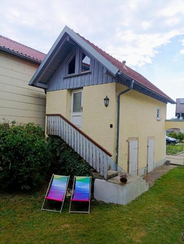 two empty chairs sitting in front of a house at Tinyhouse Loisl in Thyrnau