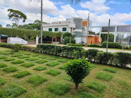 a field of grass in front of a building at Krishibid Resort 