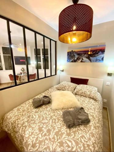 a bedroom with a bed with two clothes on it at Le Vivaldi - Studio Hypercentre Saint-Étienne in Saint-Étienne