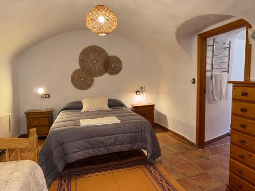 a bedroom with a bed and a dresser at Casa Cueva Sol con chimenea y piscina privada in Pozo Alcón