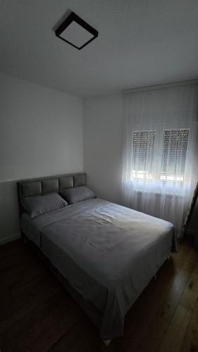a bedroom with a large bed with a window at Vozd Apartment in Belgrade