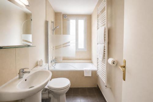 a bathroom with a sink and a toilet and a bath tub at Hôtel des Bains 24h 7j Paris centre à 10 min in Maisons-Alfort