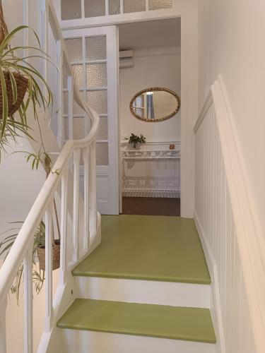 a white staircase with a green floor and a mirror at Villa Colomba - Chambre Paloma in Dunkerque