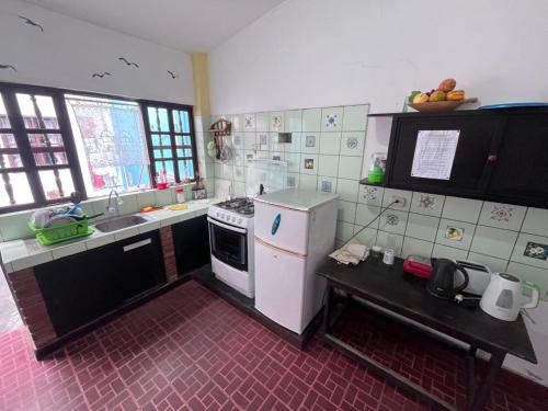 a kitchen with a white refrigerator and a sink at Wayra Hostel Huanchaco in Huanchaco