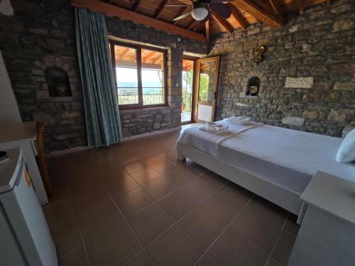 a bedroom with a large bed in a stone wall at Vama Konuk Evi in Gokceada Town