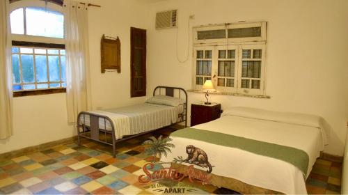 a bedroom with two beds and a window at Apart Santa Ana in Santa Ana