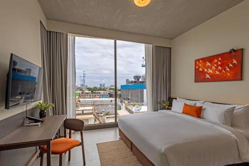 a hotel room with a large bed and a large window at Prano Hotel in Bangkok