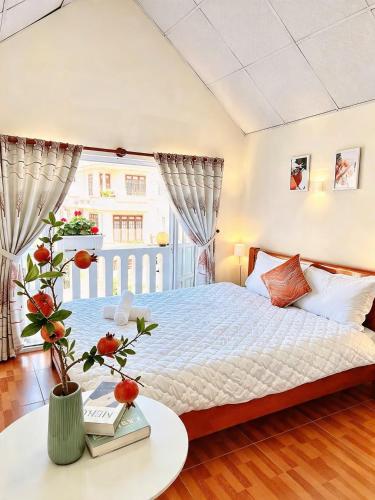 a bedroom with a bed with a table and a window at Mie House Da Lat in Xuan An