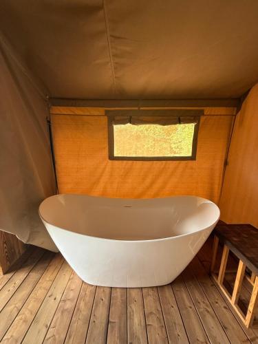 a bath tub in a tent with a window at Dworska Polana in Szteklin