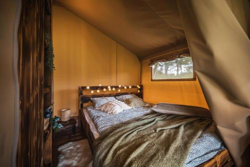 a bedroom with a bed in a tent at Dworska Polana in Szteklin