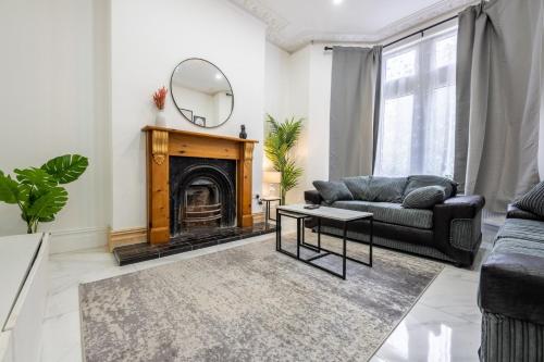 a living room with a fireplace and a mirror at Spacious 6BR Cardiff House w/ Free Parking in Cardiff