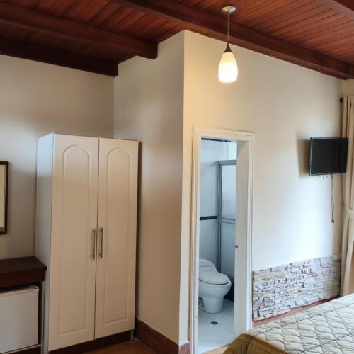 a bathroom with a toilet in a room at Hosteria Quinta Aidita in Guano