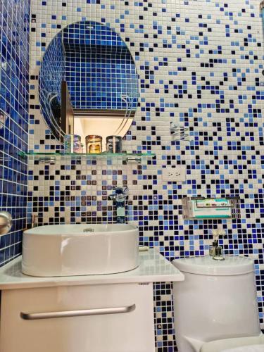 a bathroom with a sink and a mirror and a toilet at Ferry Bow in Jincheng