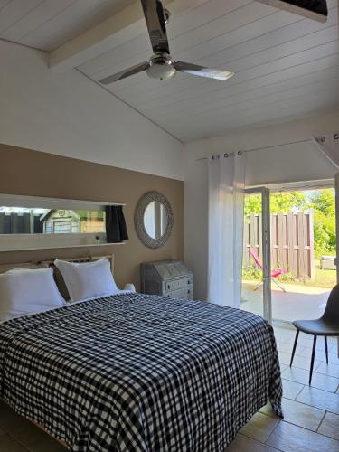 a bedroom with a bed and a ceiling fan at La parenthèse du lac in Bevaix