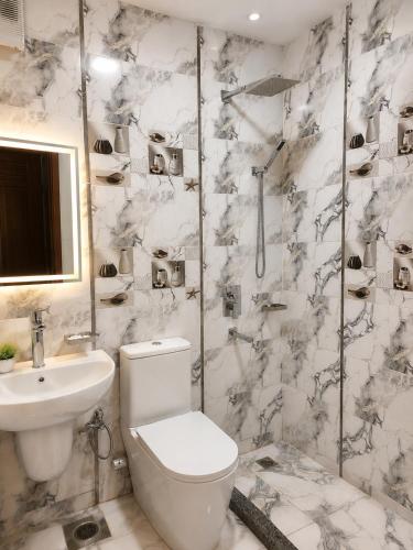 a white bathroom with a toilet and a sink at Red Pyramids Hotel in Cairo