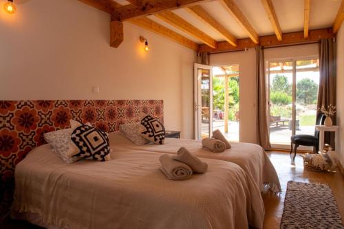 a bedroom with a large bed with pillows on it at Goodmuda in Grândola