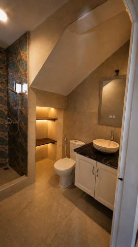 a bathroom with a toilet and a sink and a shower at Azure Villa in Belle Mare