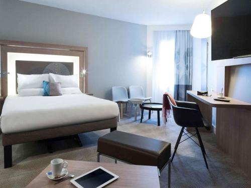 a hotel room with a bed and a desk at Novotel Château de Versailles in Versailles