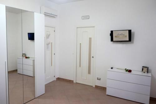 a room with white walls and a mirror at CasaMamy Residence in Pompei