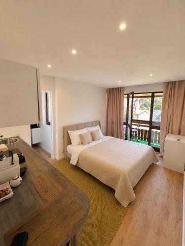 a bedroom with a large bed and a large window at Residence L'Horizon in Murat-le-Quaire