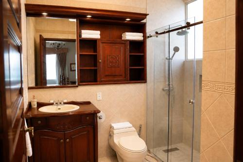 a bathroom with a toilet and a sink and a shower at Casa Aliso Hotel Boutique in Quito