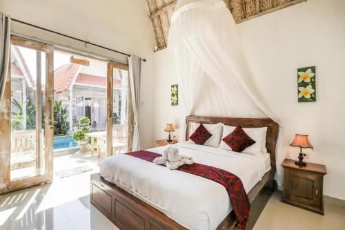 a bedroom with a bed with a teddy bear on it at The Box Paradise Bungalow in Nusa Penida