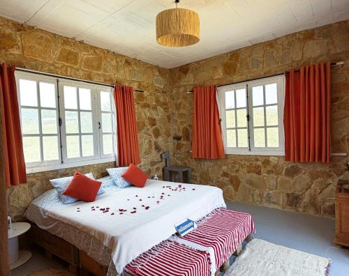 a bedroom with a large bed with red curtains at Nilamane in Asilah