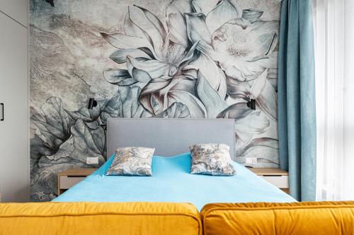 a bedroom with a bed with a flower mural at Golden Apartments in Gdańsk