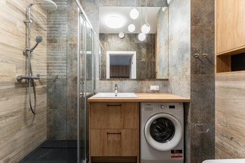 a bathroom with a washing machine and a shower at Golden Apartments in Gdańsk