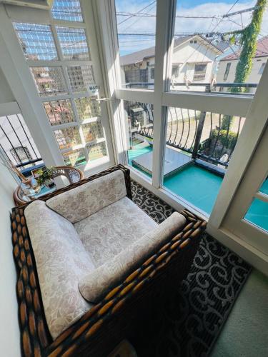 a couch in a room with a large window at Pension Green Grass in Kamakura
