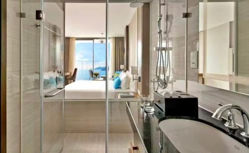 a bathroom with a tub and a sink and a bedroom at Ocean Win Panorama Nha Trang in Nha Trang