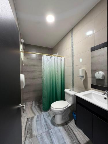 a bathroom with a toilet and a sink and a shower at Hotel Imperial in Santo Domingo de los Colorados