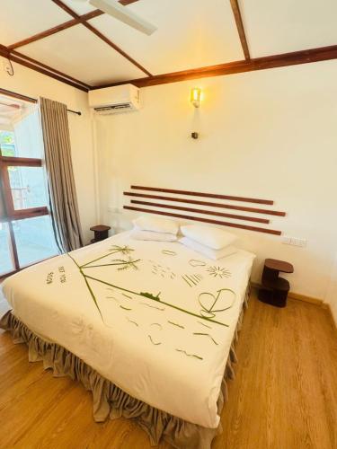 a bedroom with a bed with a white comforter at Sevenseas Seaview Maldives in Feridhoo