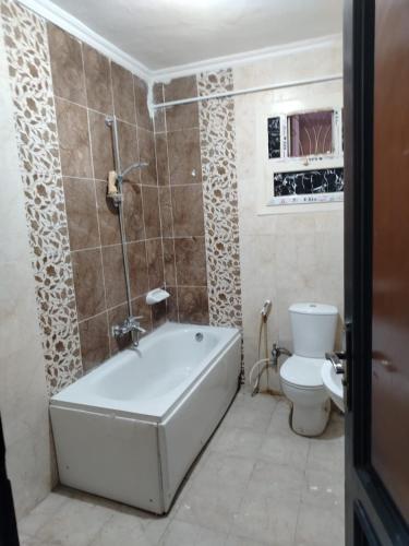 a bathroom with a bath tub and a toilet at العبور الحى التاسع in Obour
