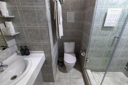 a bathroom with a toilet and a shower and a sink at Luna Hotel Astana in Astana