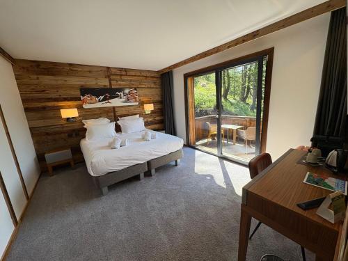 a bedroom with a bed and a table and a desk at Chalet Marano Restaurant & Spa in Isola 2000