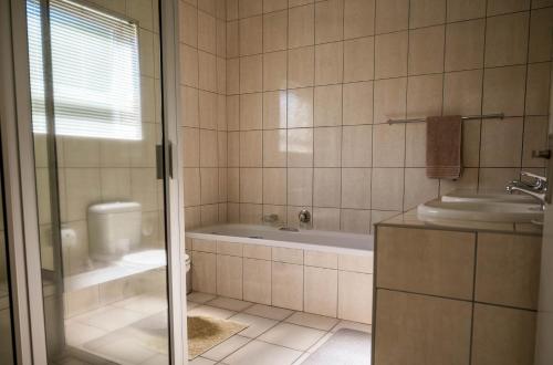 a bathroom with a tub and a sink at Monte Vidéo Guesthouse in Wellington