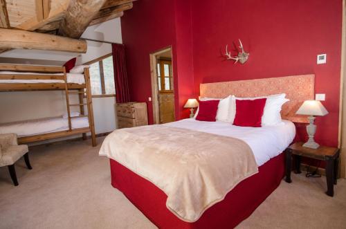 a bedroom with a large bed with red walls at Black Diamond Sainte Foy Chalets in Sainte-Foy-Tarentaise